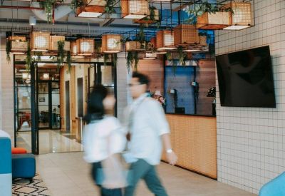 Lobby and entrance area of The Plaza Office Tower featuring artistic hanging wooden light fixtures and greenery.