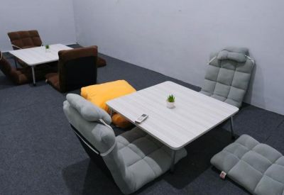 Cozy breakout area with low tables and grey floor chairs.