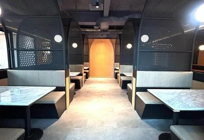 Modern communal lounge with arched semi-private booths and warm lighting.