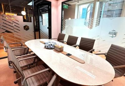 Elegant oval meeting table with leather chairs and frosted glass walls.