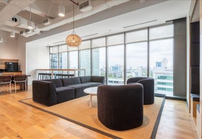 Casual meeting area with a long wooden table and cityscape views.