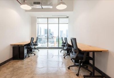 Bright workspace featuring several individual desks and ergonomic chairs.