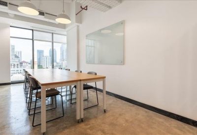 Professional meeting room with a large wall-mounted screen and natural light.