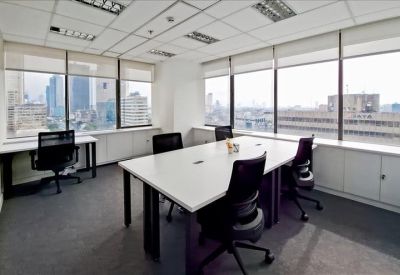 Bright corner office suite with large windows and city skyline views.
