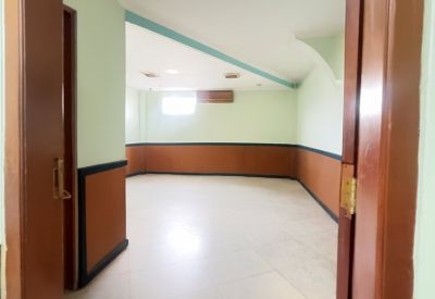 Spacious interior room at Jl. Sri Kuncoro Utara, Gang I No. Kav. 33 featuring light green walls and wood wainscoting.