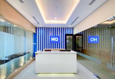 Modern lobby with a white front desk against a blue and white striped wall.