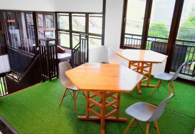 Bright coworking space featuring artificial grass flooring and large windows with greenery views.