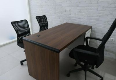 Individual wooden office desk with black mesh ergonomic seating.