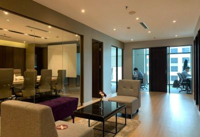 Bright boardroom with white tables and large windows showing the city skyline.