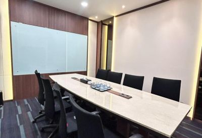 Professional boardroom with a long marble-topped table, black leather chairs, and a whiteboard.