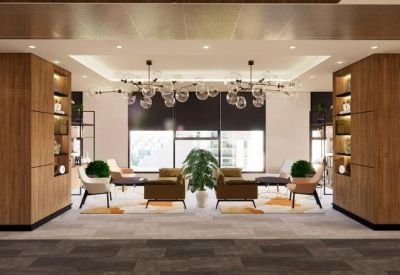 Spacious communal lounge with wooden shelving, globe lighting, and plush seating.