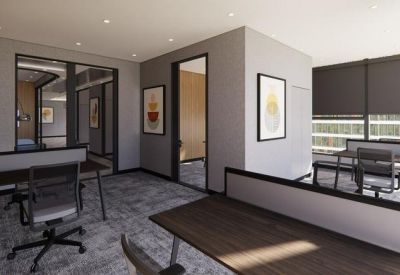 Modern open-plan office featuring wood-topped desks and ergonomic chairs.