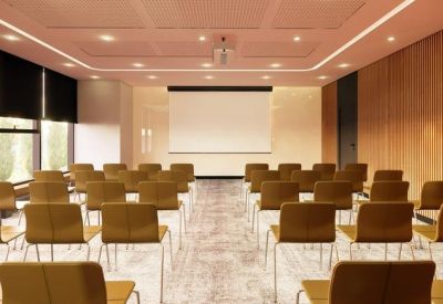 Large meeting room with rows of chairs facing a presentation screen.