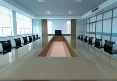 Modern boardroom with a long conference table and black chairs.