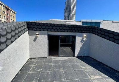 Private rooftop terrace with grey tiling and views of nearby city buildings.