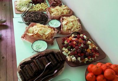 Long buffet table spread with a variety of fresh fruits, snacks, and appetizers for events.
