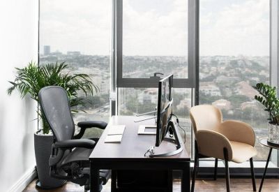 Private office with a dark wood desk, ergonomic chair, and floor-to-ceiling windows.