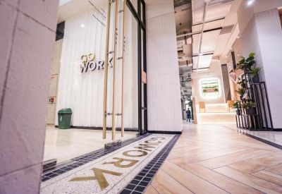 Entrance to the Plaza Indonesia serviced offices featuring glass doors and a branded tile inlay floor.