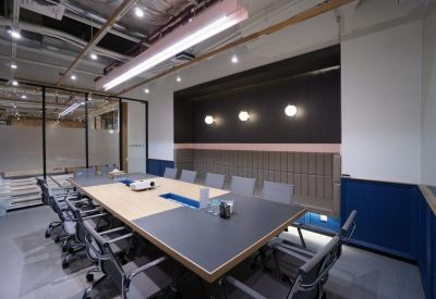 Professional meeting room with a large rectangular table, navy blue walls, and ergonomic chairs.