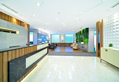 Spacious reception area featuring a wood-paneled desk and a vibrant green living wall.