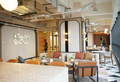 Spacious communal lounge with plush seating, geometric patterned flooring, and a decorative #TogetherWeGrow wall.