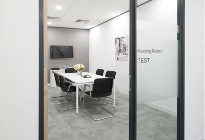 Modern meeting room with a glass door and seating for six people.