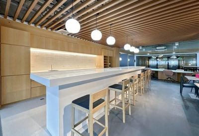 Long white breakfast bar with wooden slatted ceiling and pendant lights.
