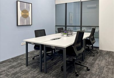 Modern four-person workspace with white desks and mesh-back chairs.