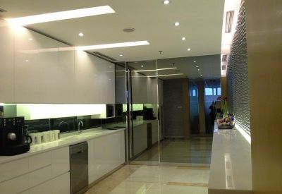 Bright communal kitchen with white cabinetry, modern appliances, and polished stone flooring.