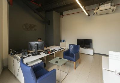 Reception area with blue leather armchairs and a dark accent wall.