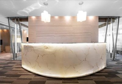 Bright reception area featuring a curved marble desk with under-counter lighting.