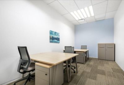 Formal boardroom featuring a long wooden table and ergonomic tan leather chairs.