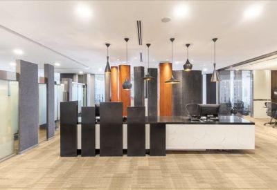 Sleek reception area with dark wood paneling, designer light fixtures, and a white front desk.