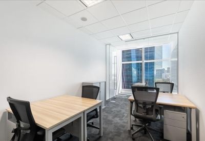 Bright private four-person office with blonde wood desks and floor-to-ceiling windows.