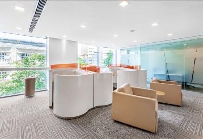 Open communal lounge area with curved white privacy booths and soft seating.