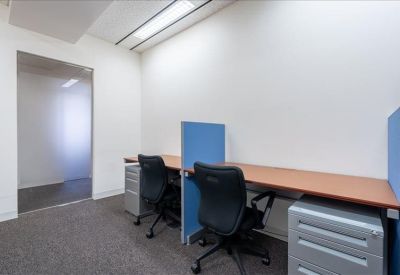 Two-person workspace with wood-finish desks and blue privacy dividers.