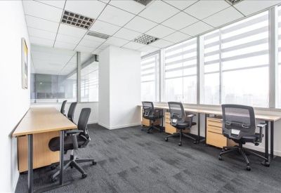 Bright private office with multiple desks facing large windows with city views.