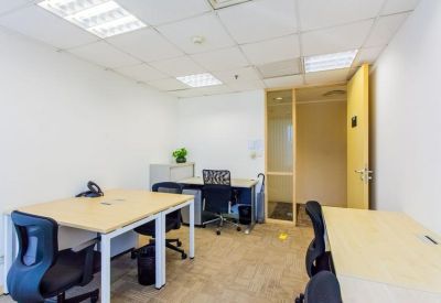 Bright private office suite with multiple light wood desks and ergonomic chairs.