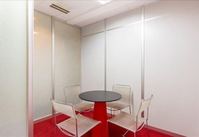 Small meeting room with a round table, red central pillar, and four chairs.