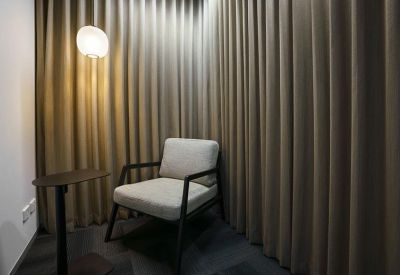 Private nook with a comfortable armchair and floor-to-ceiling curtains for privacy.