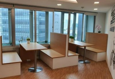 Breakout area with wooden booth seating and tables overlooking large windows.