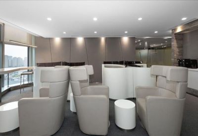 Communal lounge area with high-back privacy chairs and small coffee tables.