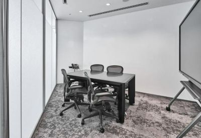 Small private office suite with a dark wood table and four ergonomic chairs.