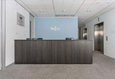Sleek dark wood reception desk set against a bright white wall and light blue backdrop.