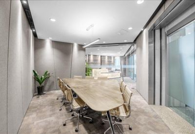 Professional boardroom with a wooden table and a green plant.