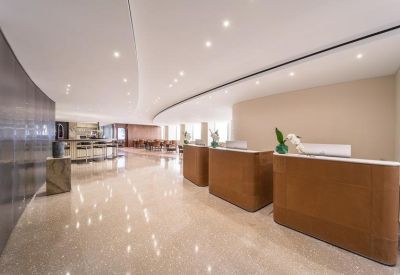 Professional reception area with three wooden desks and a polished stone floor.