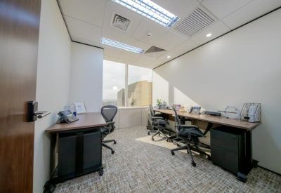 Small shared office suite with wooden desks, filing cabinets, and a window view.