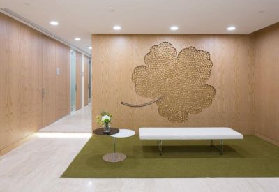 Communal lounge area featuring a large leaf-shaped wall art piece and white bench seating.