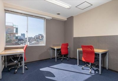 Private office suite with three desks and red ergonomic mesh chairs by a window.