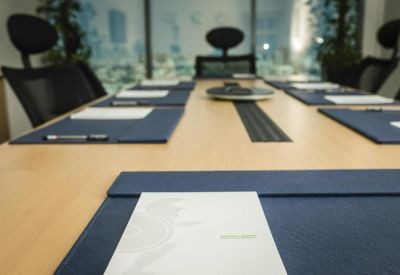 Professional meeting room table set with navy leather desk pads.